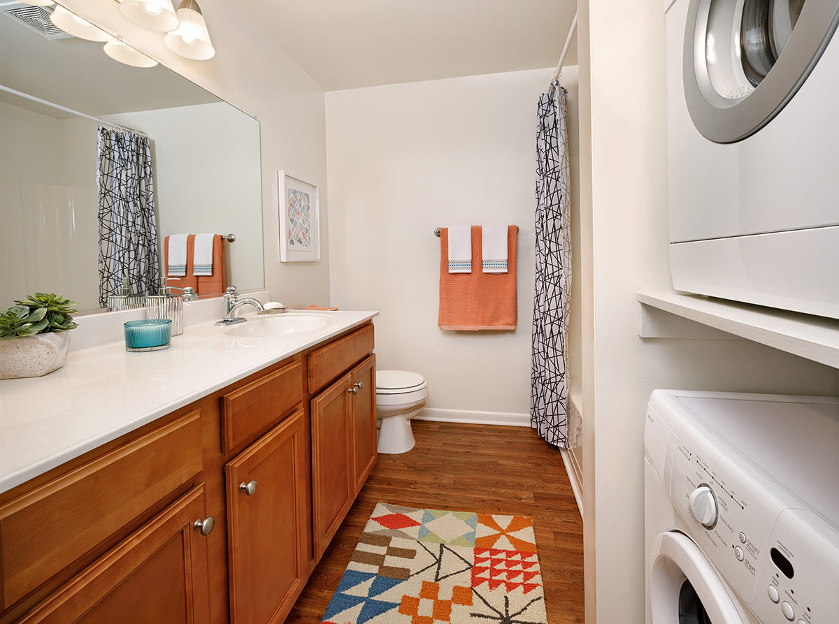 A stylish bathroom that includes a washer and dryer at Northampton Reserve in Hampton, Virginia