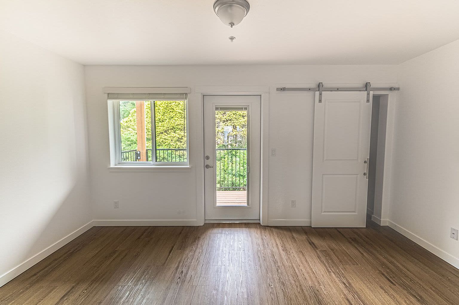 Spacious room with wood floors leading to patio at Pine View in La Pine, Oregon