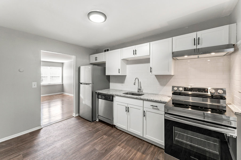 Beautiful kitchen with wood-style flooring at Gardens at Washington Park in Atlanta, Georgia