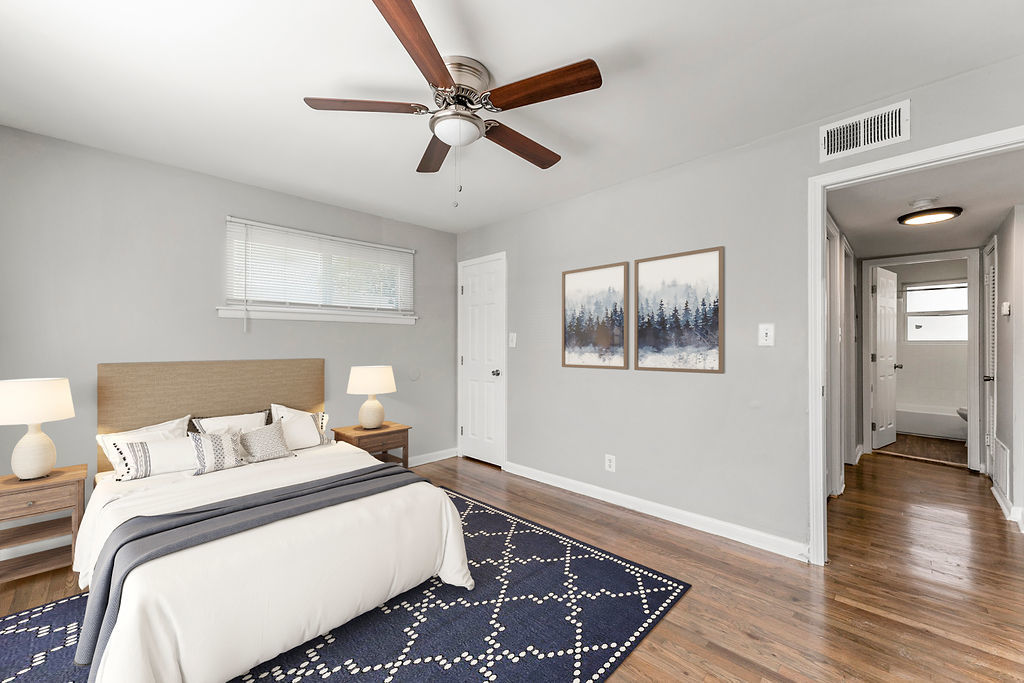 Bedroom with a spacious bed and a ceiling fan at Gardens at Washington Park in Atlanta, Georgia