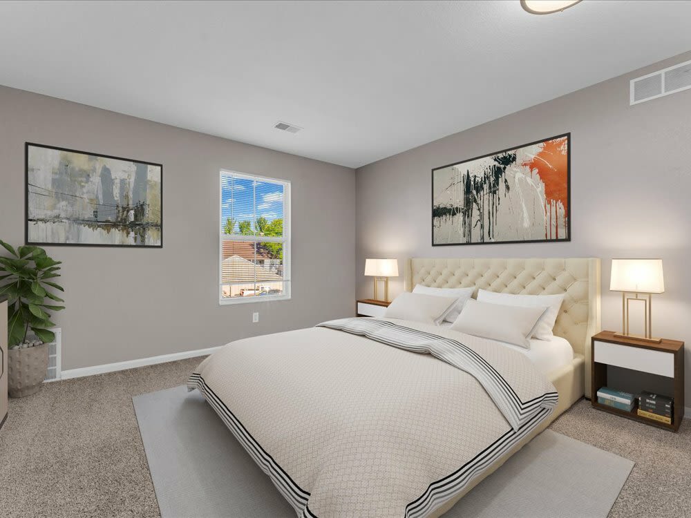 A bed in a bedroom of the apartment at Wyndham Hill in Grand Rapids, Michigan