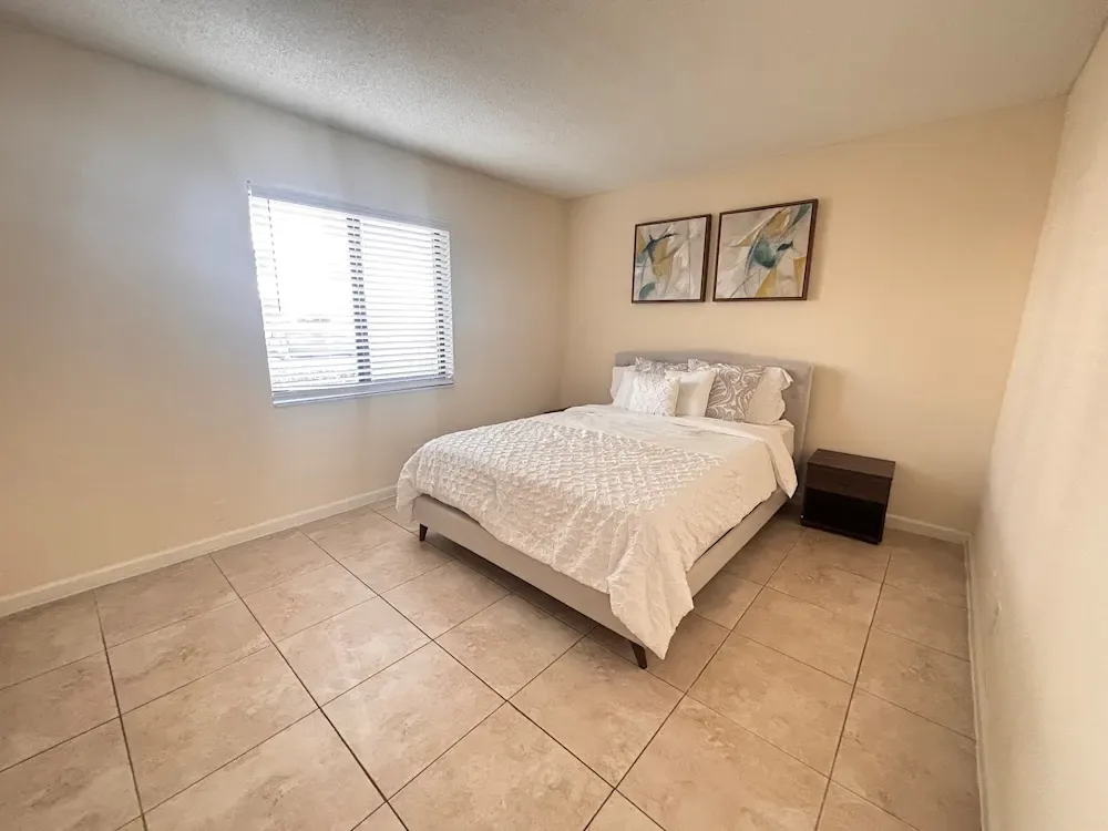 Well-lit bedroom with large windows at Banyan Club East in Pompano Beach, Florida
