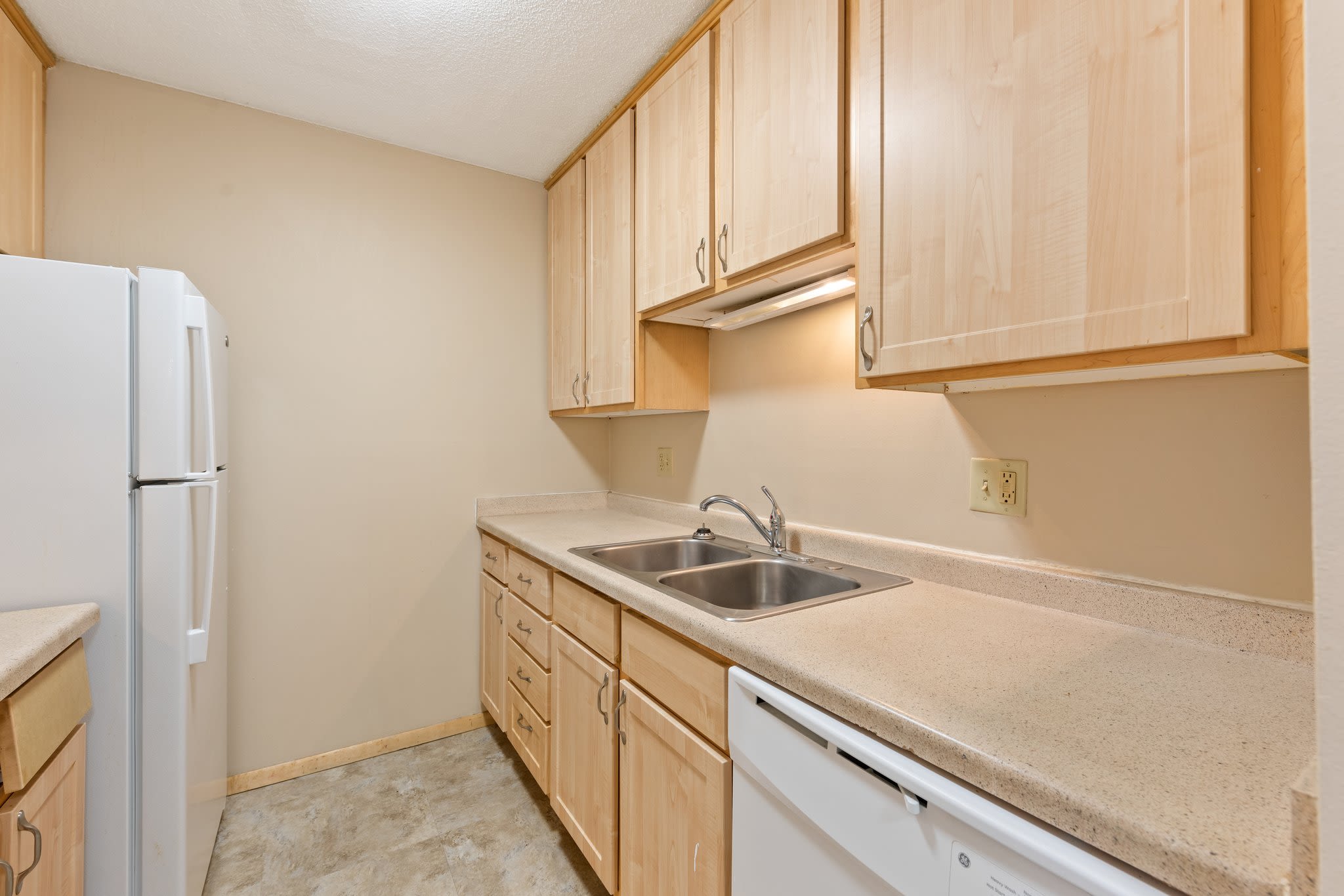 Apartment kitchen with wooden cabinets at Shamrock Court Apartments in Saint Paul, Minnesota