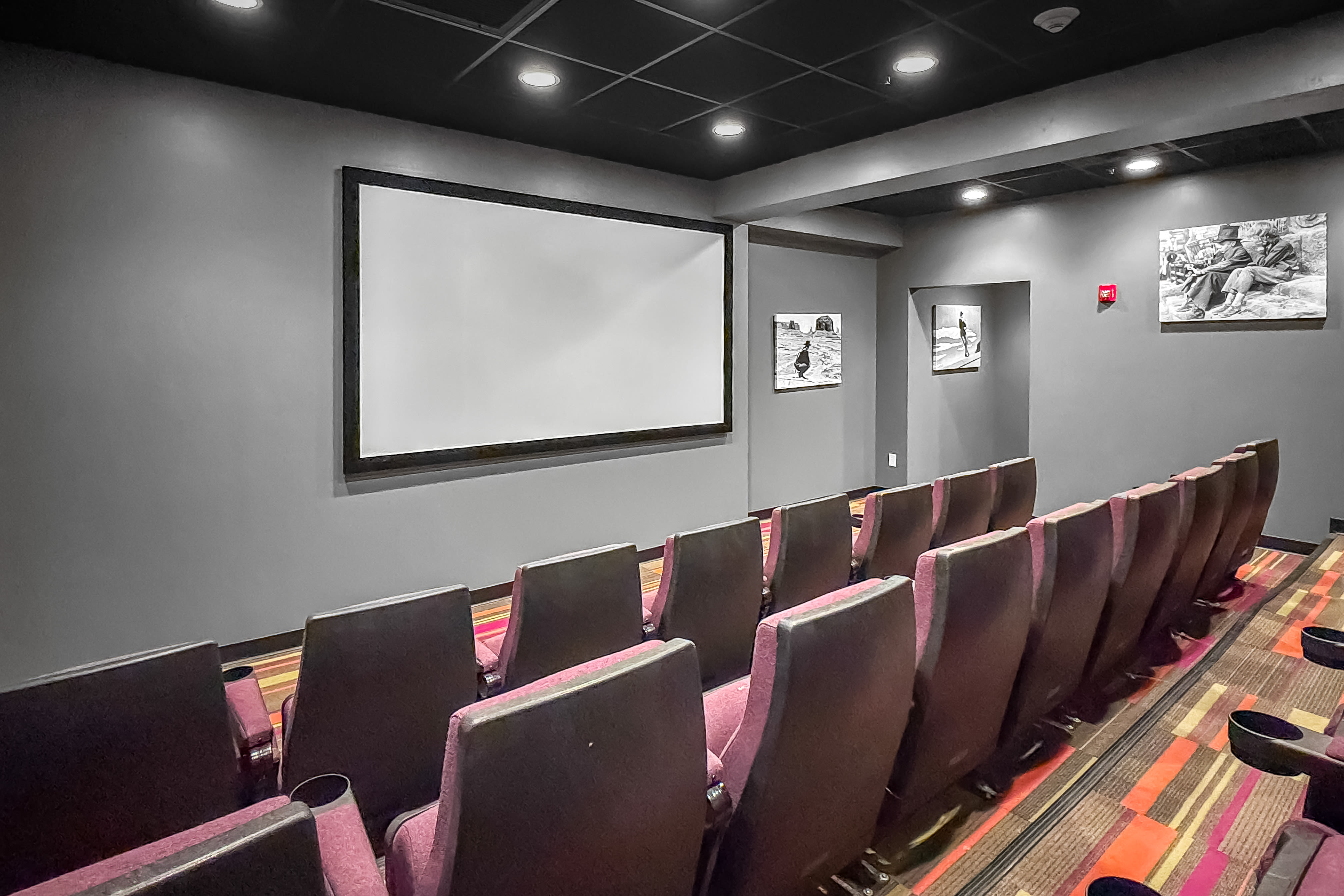 Classic movie theater with rows of recliner seating and large projector screen at The Franklin in Ankeny, Iowa
