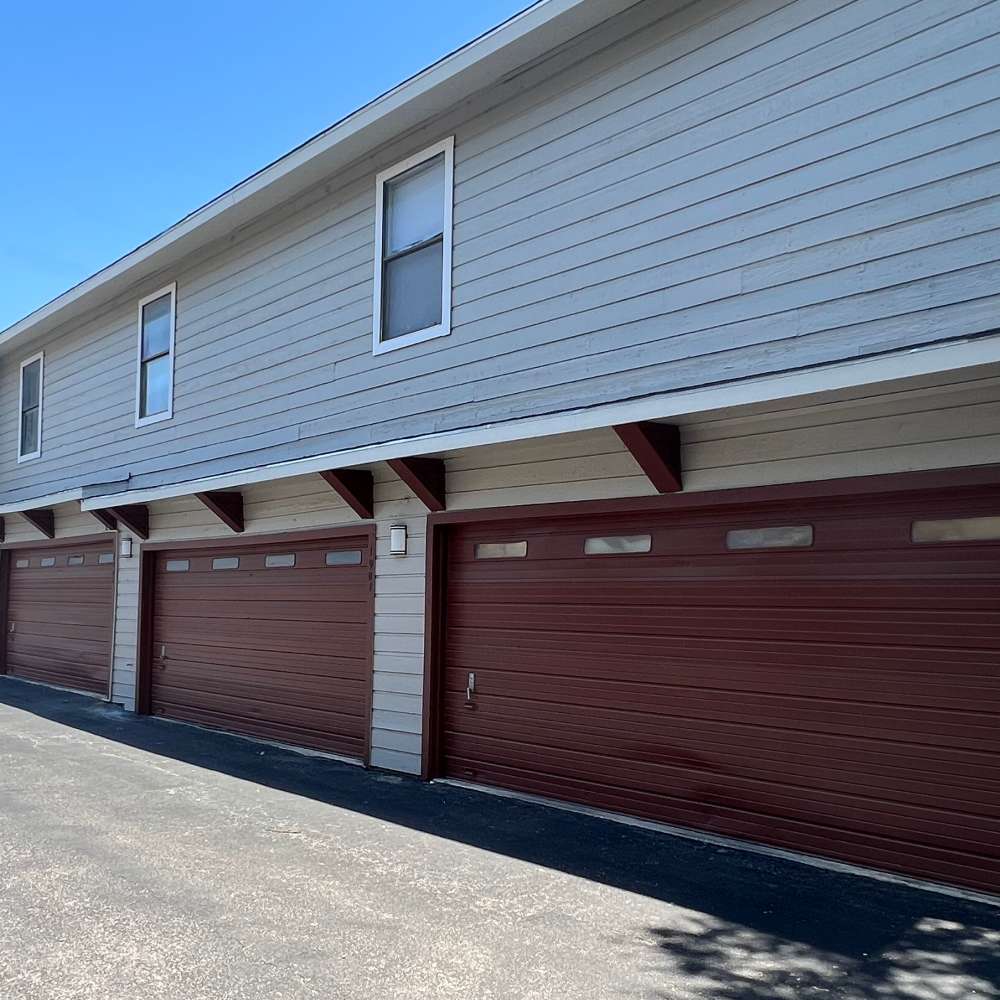 Brown garage doors with windows at The Camaron Townhomes & Flats in San Antonio, Texas