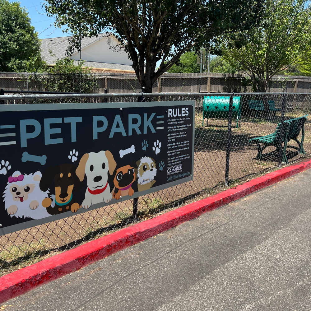 Green benches and a fenced area at The Camaron Townhomes & Flats in San Antonio, Texas