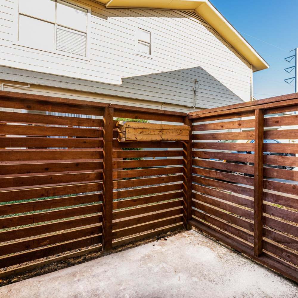 Wooden slatted fence with concrete floor at The Camaron Townhomes & Flats in San Antonio, Texas