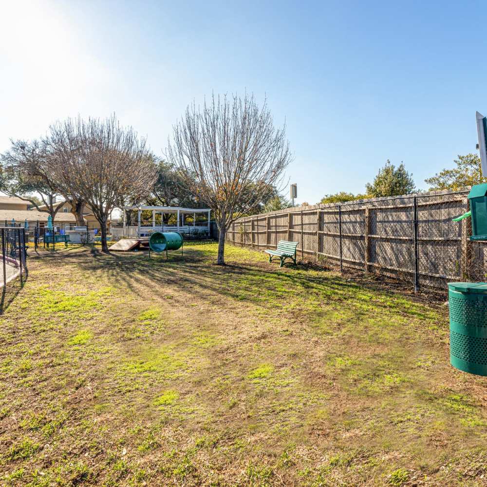 Fenced area with benches and trees at The Camaron Townhomes & Flats in San Antonio, Texas
