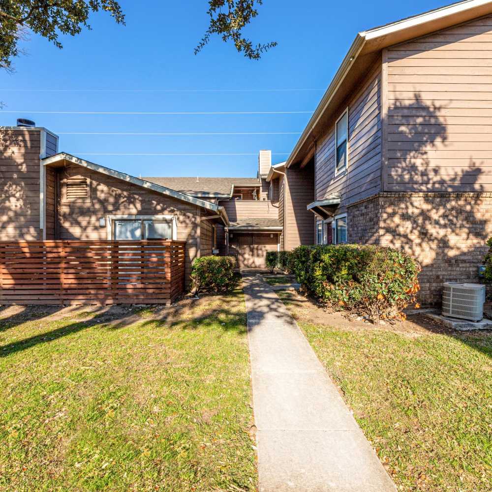 Sidewalk leading to buildings and greenery at The Camaron Townhomes & Flats in San Antonio, Texas