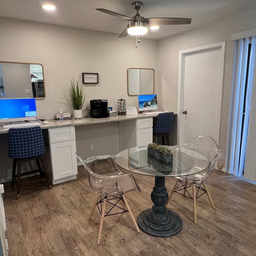 Glass table with clear chairs and workspace at The Camaron Townhomes & Flats in San Antonio, Texas