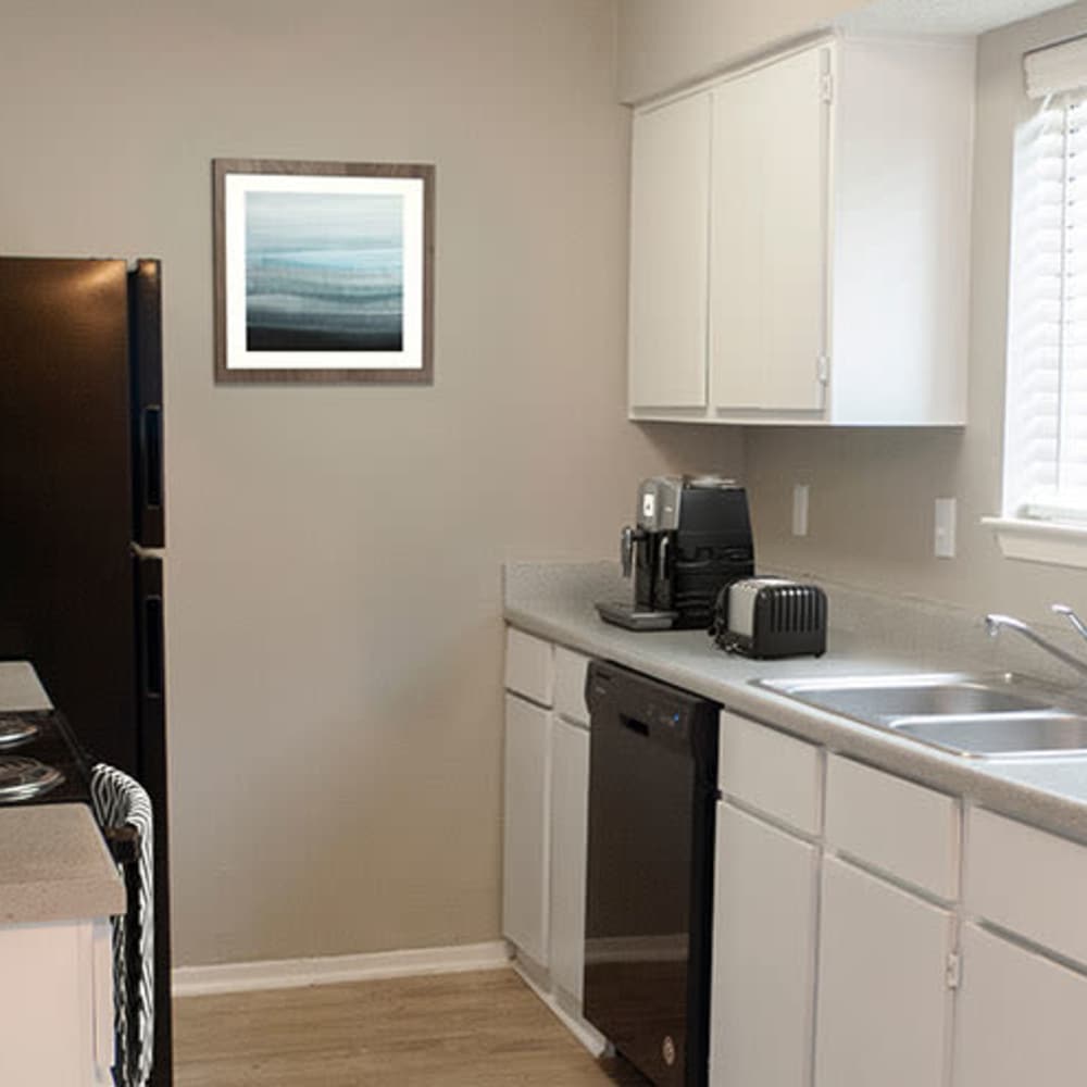 Black refrigerator and white cabinets at The Camaron Townhomes & Flats in San Antonio, Texas