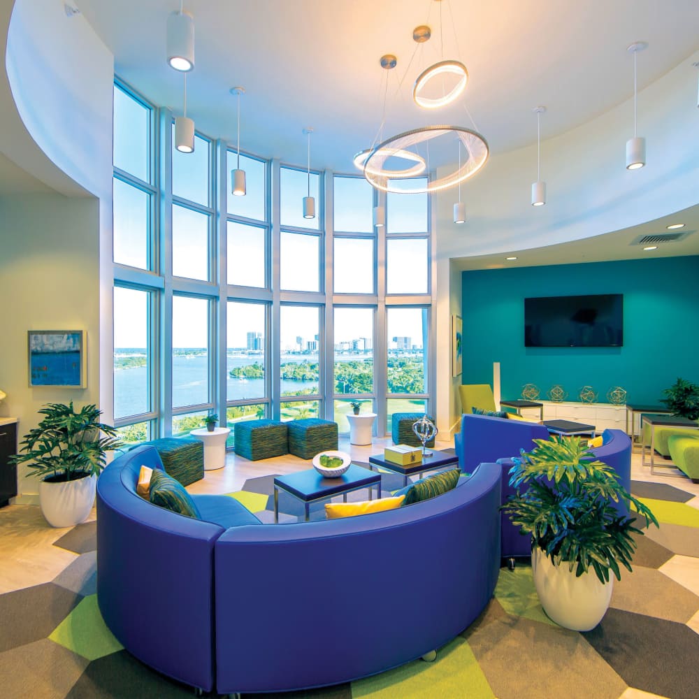 Lounge area with large windows and modern decor at Bayview Student Living in North Miami, Florida