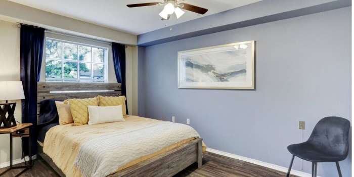 Modern bedroom with large comfortabe bed at Treemont Senior Community in Houston, Texas