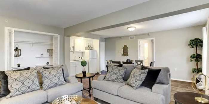 Gray sofas with patterned pillows and coffee table at Treemont Senior Community in Houston, Texas
