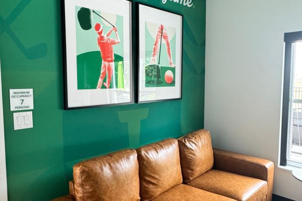 Cozy seating area with golf-themed artwork at Pritchard Park Place in Racine, Wisconsin
