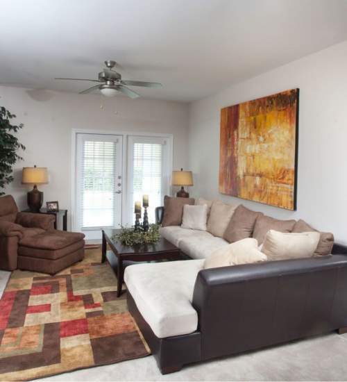Living room with sectional sofa and artwork at Chapel Creek in Mandeville, Louisiana