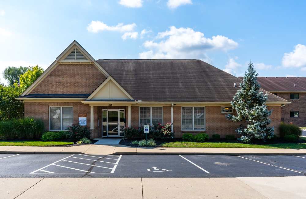 Brick building with landscaped entrance at Indian Footprints Apartments in Harrison, Ohio