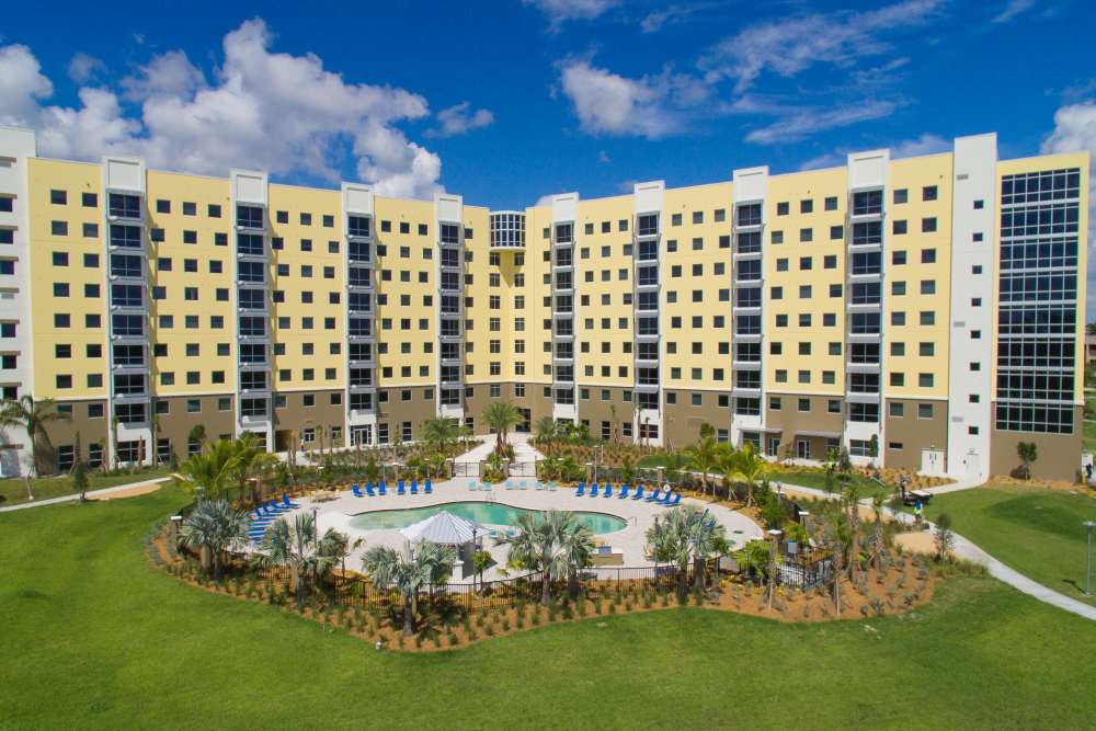Modern apartment community with resort-style pool, lush landscaping, and spacious outdoor seating areas at Bayview Student Living in North Miami, Florida