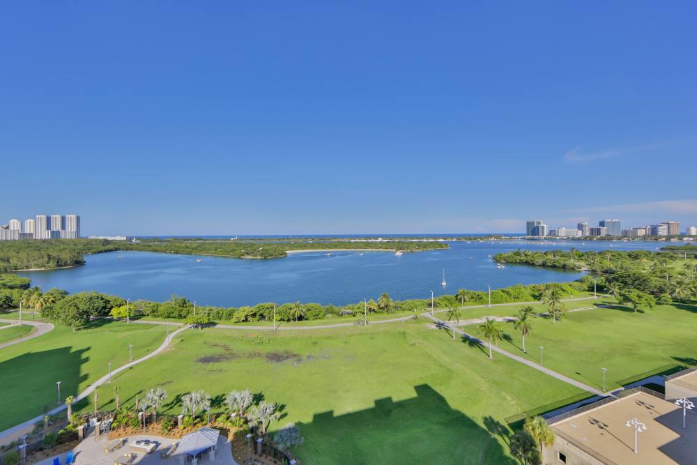Lush green park with winding paths and waterfront views under a clear blue sky at Bayview Student Living in North Miami, Florida