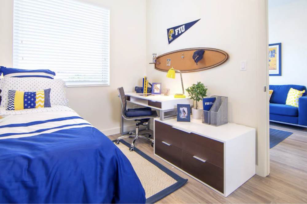 Student bedroom with desk and blue decor at Bayview Student Living in North Miami, Florida