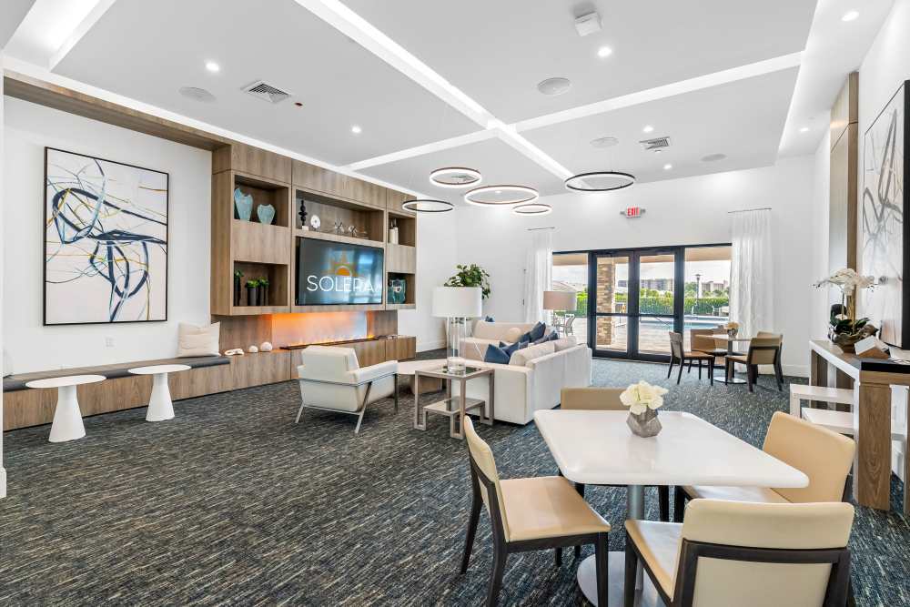 Stylish community lounge with modern seating and natural light, showcasing a vibrant decor and inviting atmosphere at Solera at Avalon Trails in Delray Beach, Florida