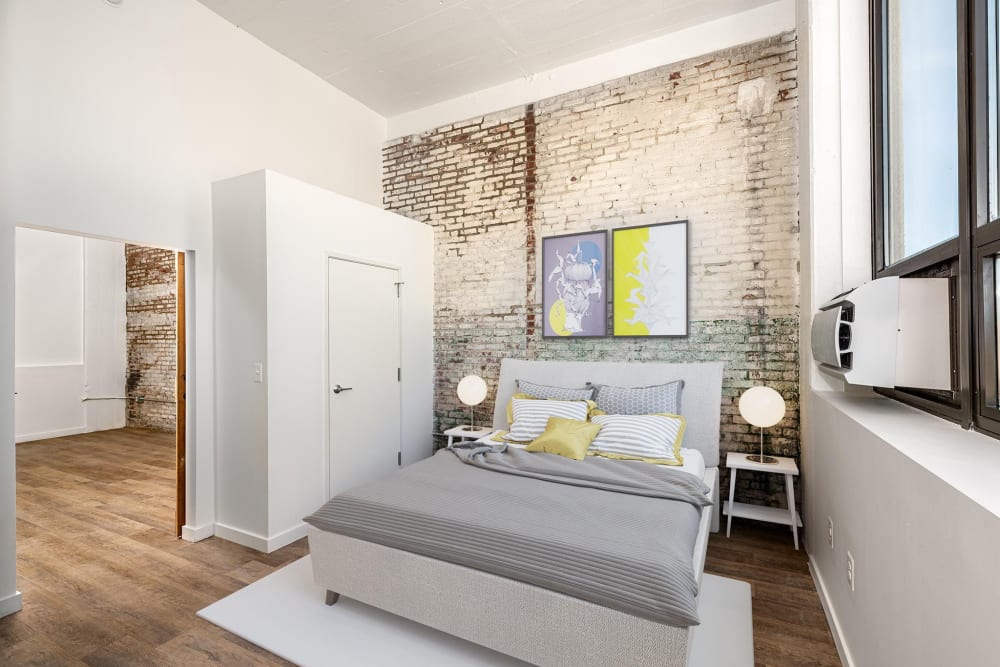 Bed with gray bedding and decorative pillows at Brush Factory Lofts in Philadelphia, Pennsylvania