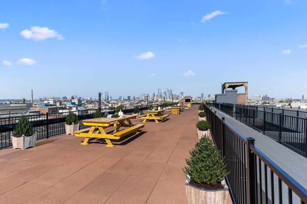 Rooftop with yellow picnic tables and planters at Brush Factory Lofts in Philadelphia, Pennsylvania