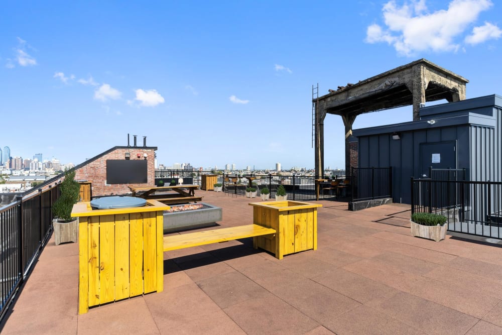 Yellow tables on rooftop with city skyline at Brush Factory Lofts in Philadelphia, Pennsylvania