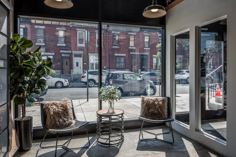 Two chairs with cushions and a table at Brush Factory Lofts in Philadelphia, Pennsylvania