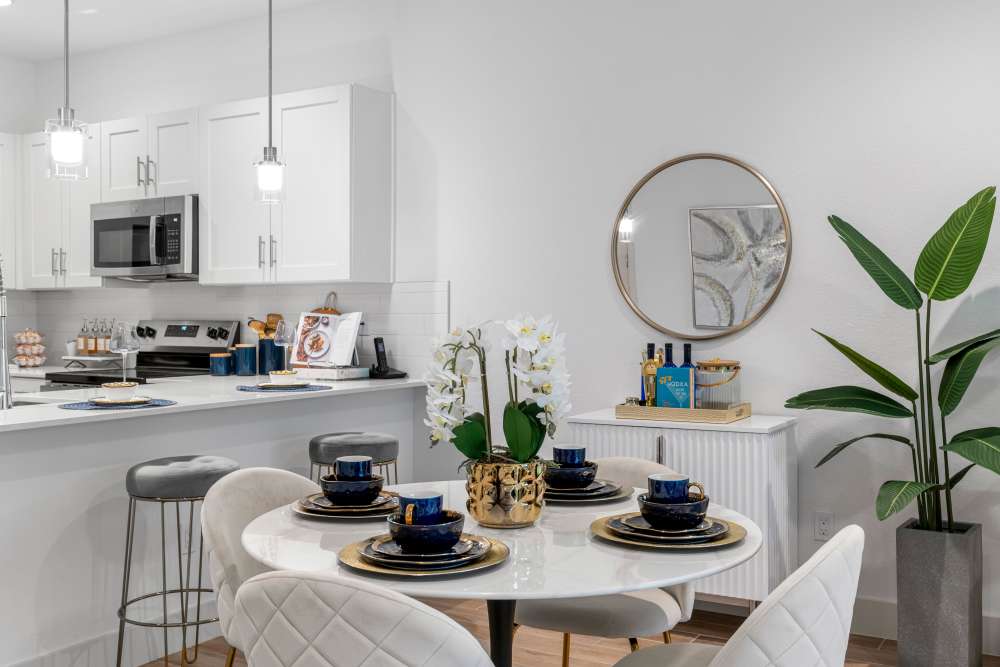 Modern kitchen with stainless steel appliances and granite countertops, stylish dining area with elegant decor at Solera at Avalon Trails in Delray Beach, Florida