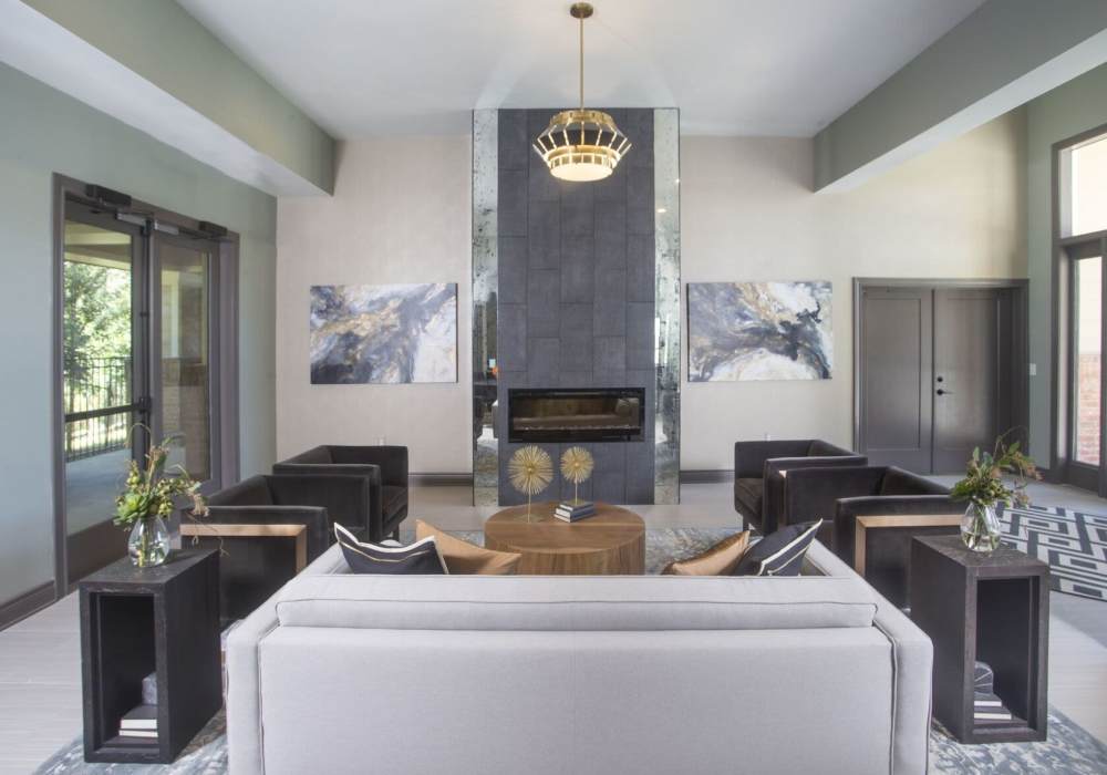 Living room with modern furnishings, fireplace, and large windows at Lakeside Villas in Baton Rouge, Louisiana