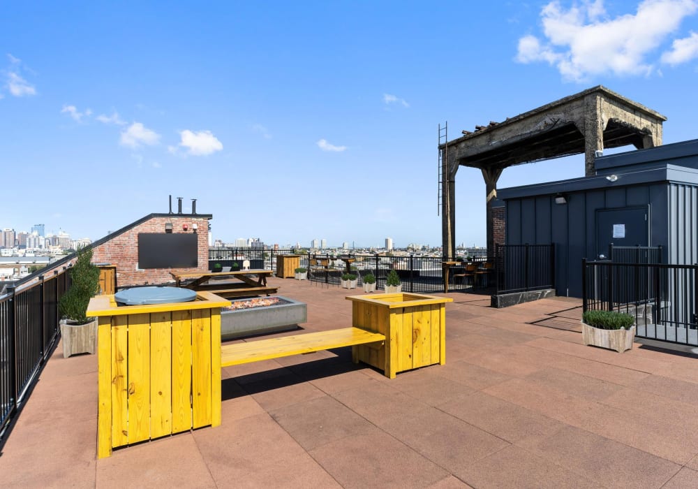 Yellow picnic tables on rooftop terrace at Brush Factory Lofts in Philadelphia, Pennsylvania
