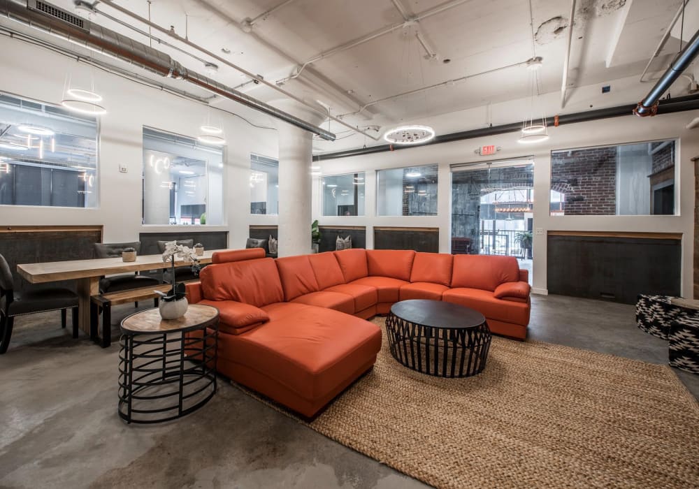 Orange sectional sofa with round coffee table at Brush Factory Lofts in Philadelphia, Pennsylvania