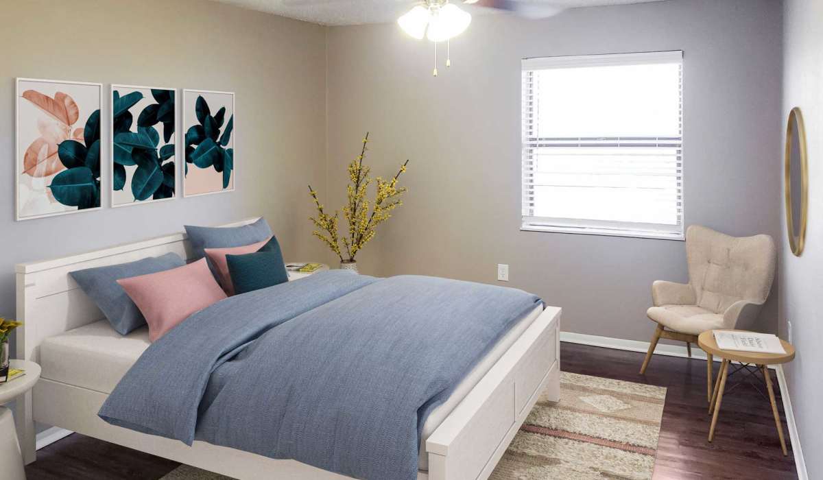 Bright bedroom with wood-style flooring, modern decor, and large window providing natural light at Riatta Ranch Apartments in Abilene, Texas