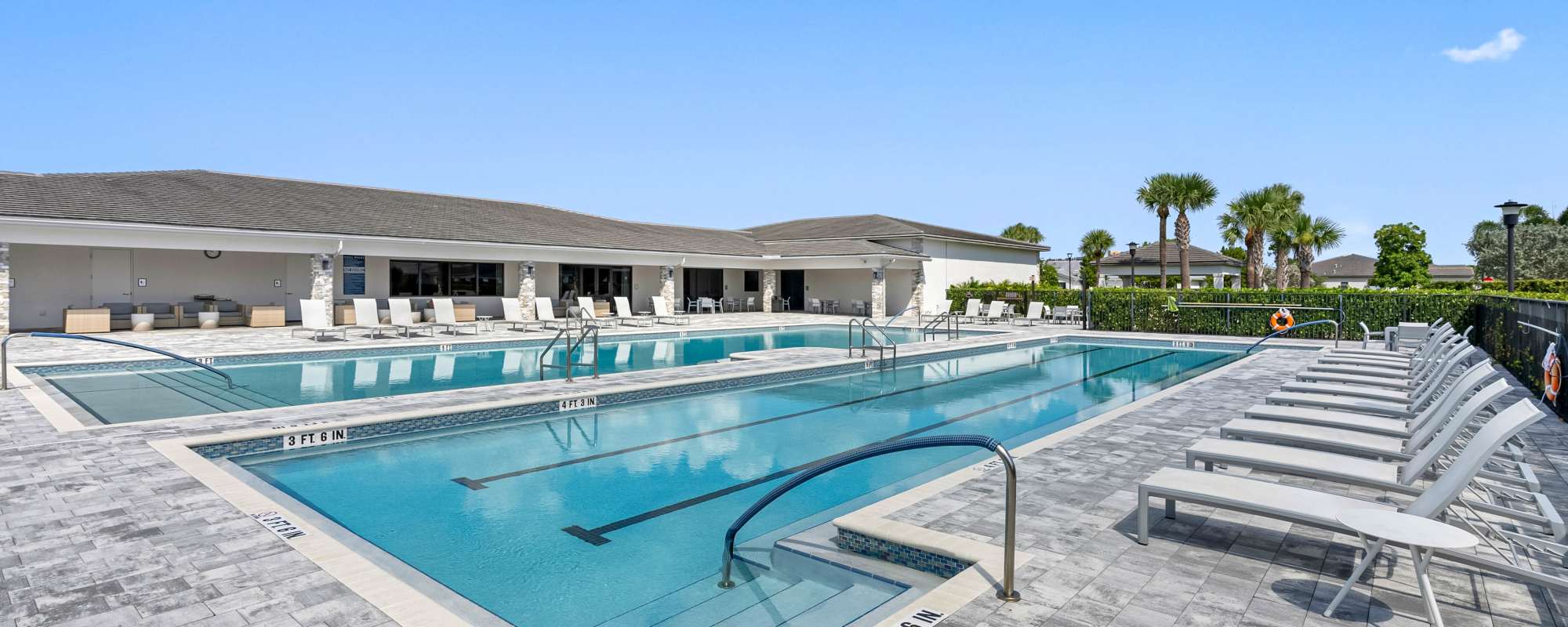 Swimming pool with lounge chairs at Solera at Avalon Trails in Delray Beach, Florida