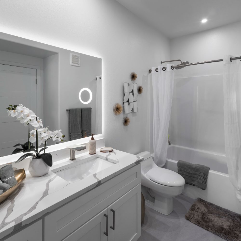 Bathroom with vanity, lighted mirror, tub, and a shower at Continuum Apartments in Las Vegas, Nevada