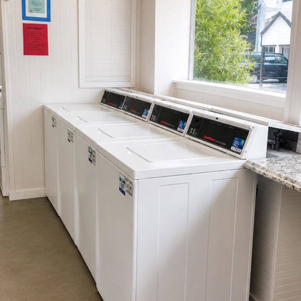 Bright laundry room with multiple washers at Serenity at Cityside in Houston, Texas