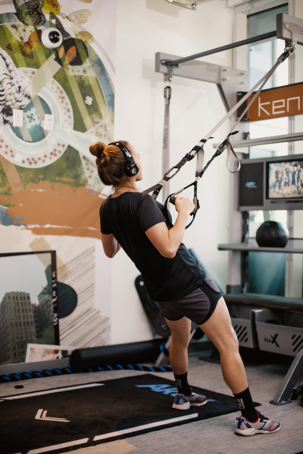Resident working out in the fitness studio with TRX equipment at Kenect Phoenix in Phoenix, Arizona