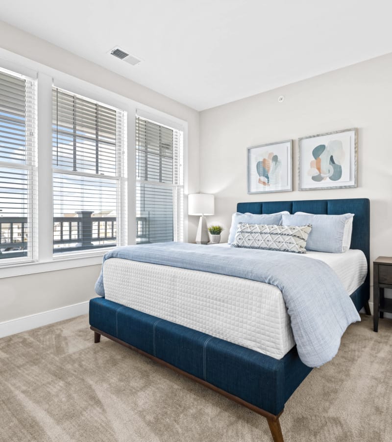 Bedroom with large windows at Village Square Apartments in Norfolk, Virginia