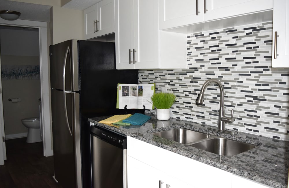 Contemporary kitchen with tile backsplash and white cabinetry at The Preserve on Allisonville in Indianapolis, Indiana