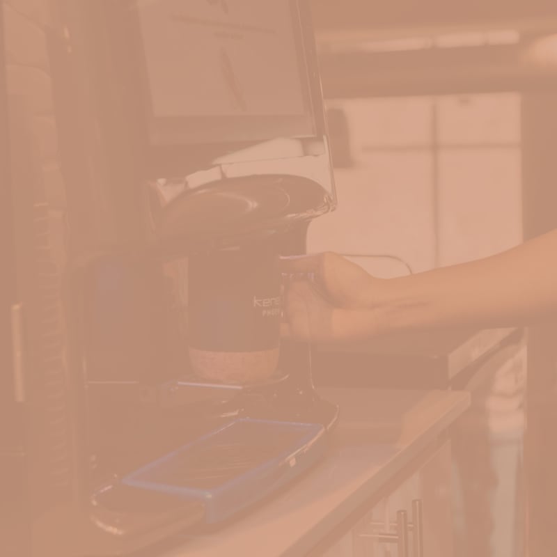 Member pouring a cup of coffee from the coworking space's kitchen at Kenect Phoenix in Phoenix, Arizona