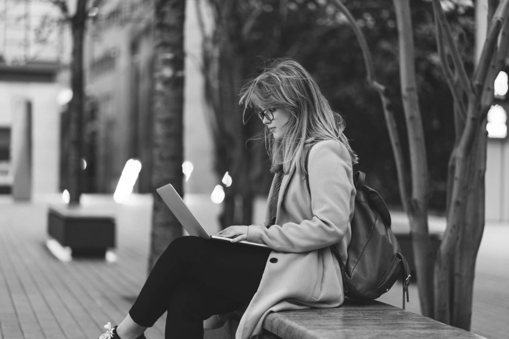 Resident working on her laptop outside near IDENTITY Boise in Boise, Idaho