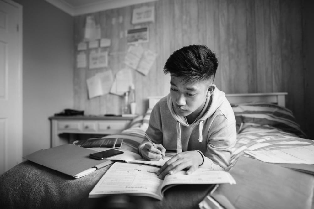 Resident doing homework in his room at IDENTITY Moscow in Moscow, Idaho