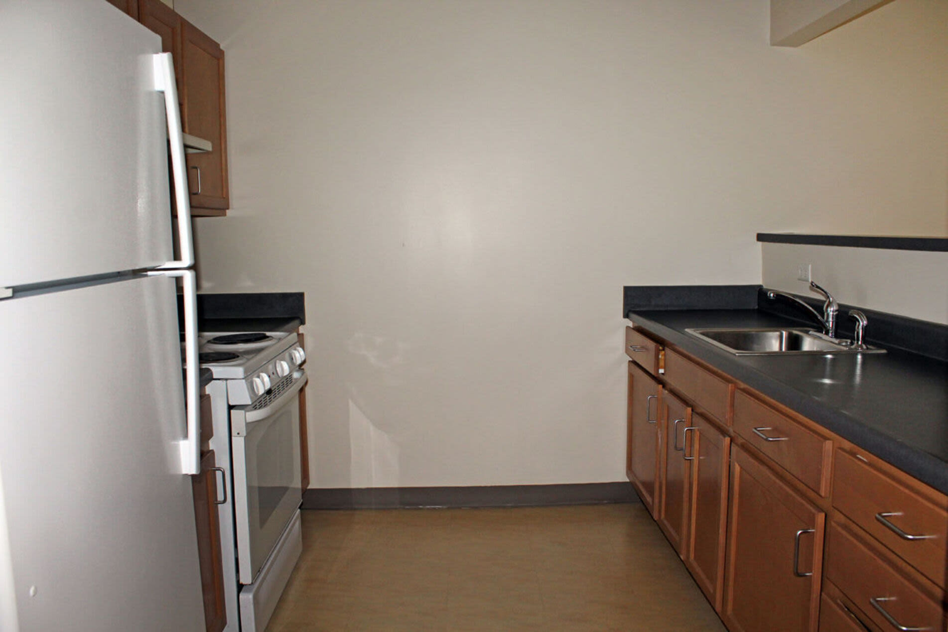 Fully equipped kitchen with granite countertops stainless steel appliances like a refrigerator, stove, and drawer microwave at 270 Centre Street in Jamaica Plain, Massachusetts