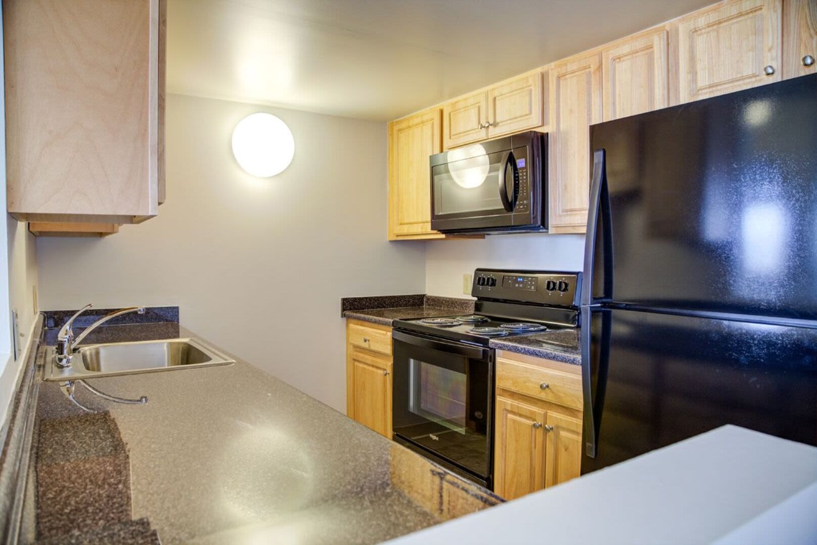 Modern kitchen with wooden cabinets at Anchors Weigh in Chelsea, Massachusetts