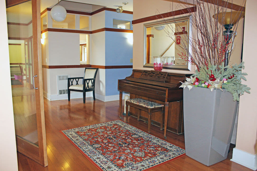 Indoor lounge with a piano at Angela Westover House in Jamaica Plain, Massachusetts