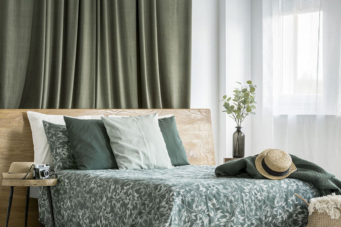Cozy bedroom with night stand and window at Brook Avenue Apartments in Roxbury, Massachusetts