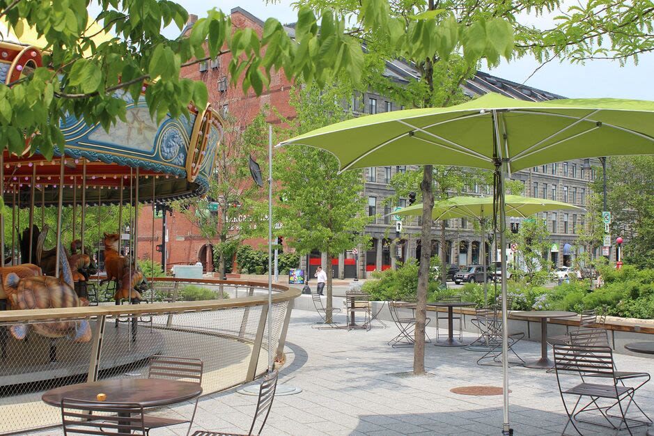 Exterior view of the garden-style property with carousel in park at Mercantile Wharf in Boston, Massachusetts