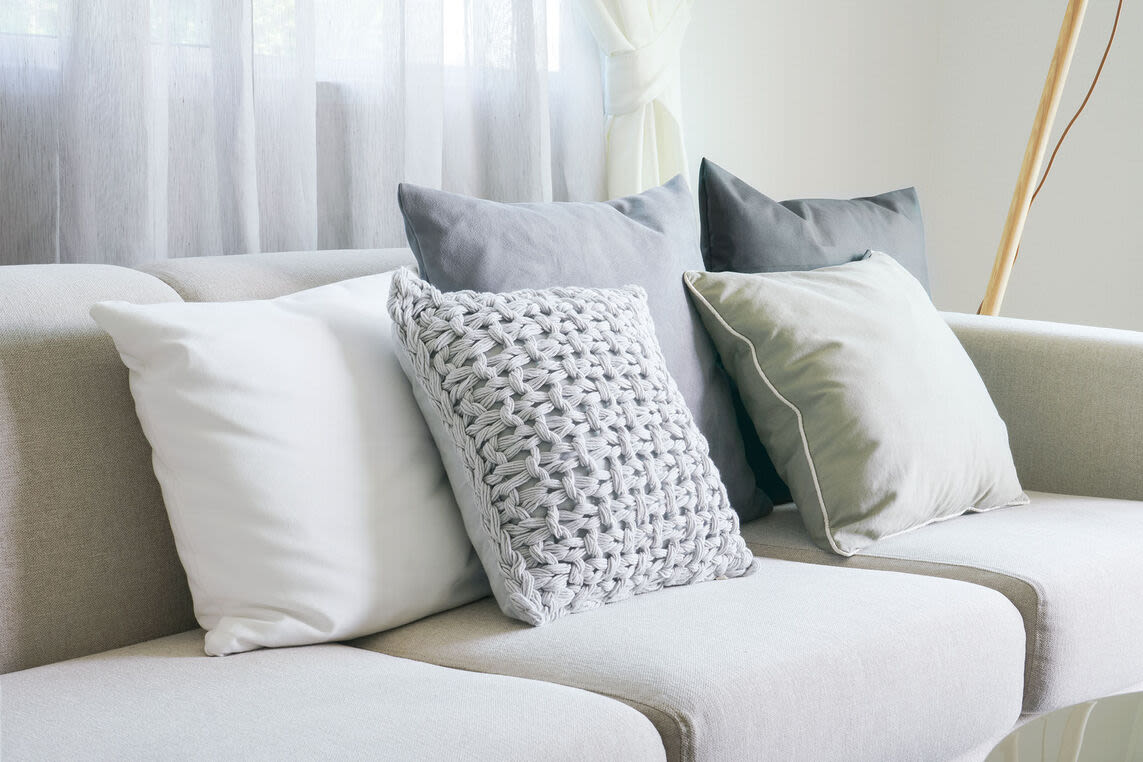 Close up of a white couch with throw pillows at Peterborough Apartments in Boston, Massachusetts