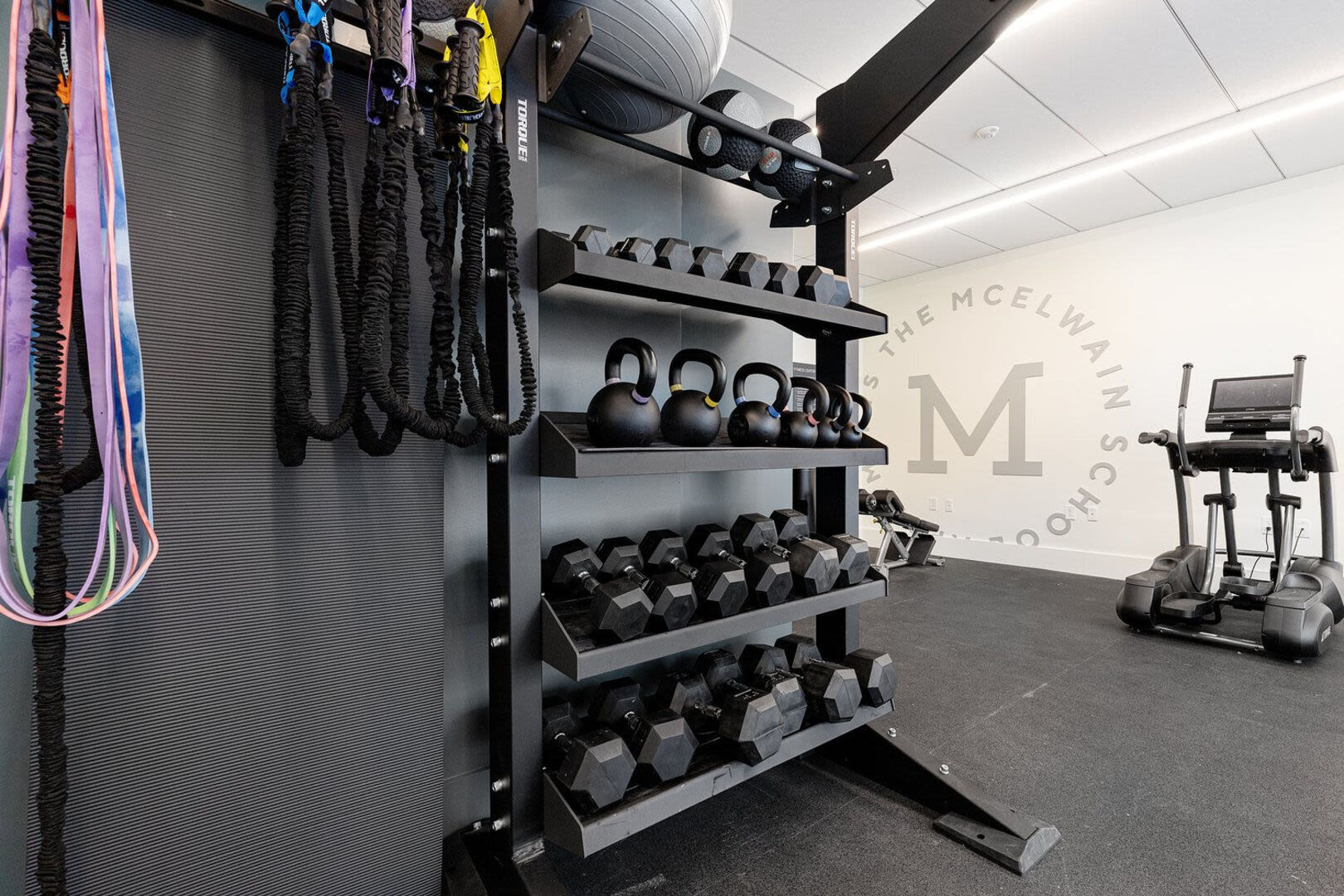 Fitness center with weight racks and stretching bands at The Mcelwain School Apartments in Bridgewater,Massachusetts